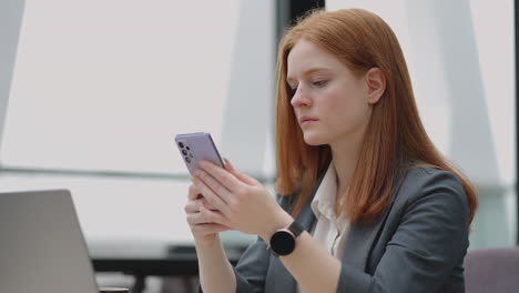 Geschäftsfrau-Mit-Smartwatch-Und-Modernem-Mobiltelefon-Im-Büro-überprüft-Die-Bekanntmachung-In-Apps-Und-Sozialen-Medien